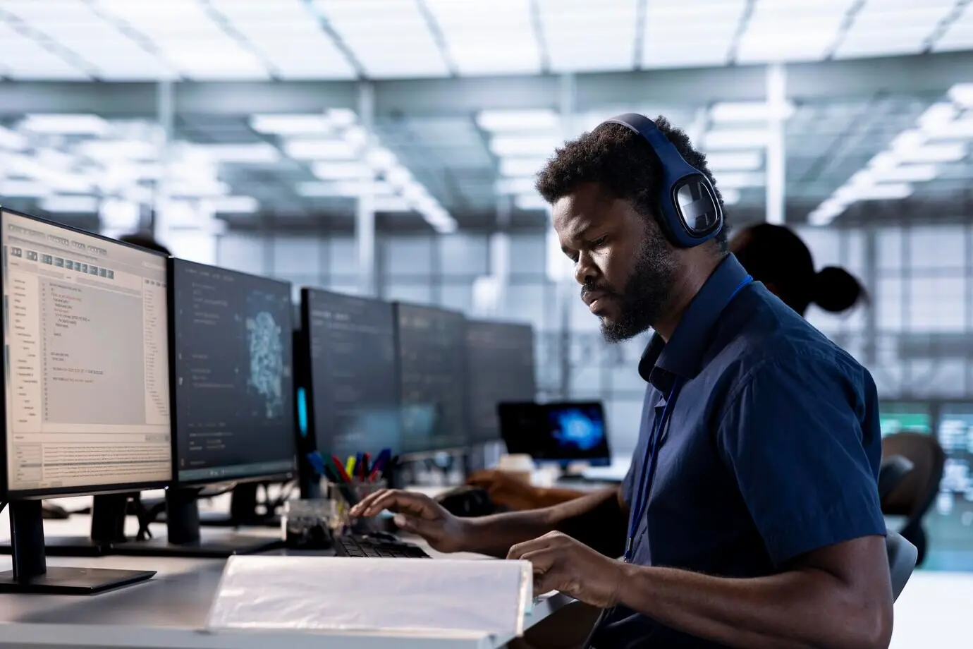 Программист в серверной слушает музыку и просматривает бумаги.