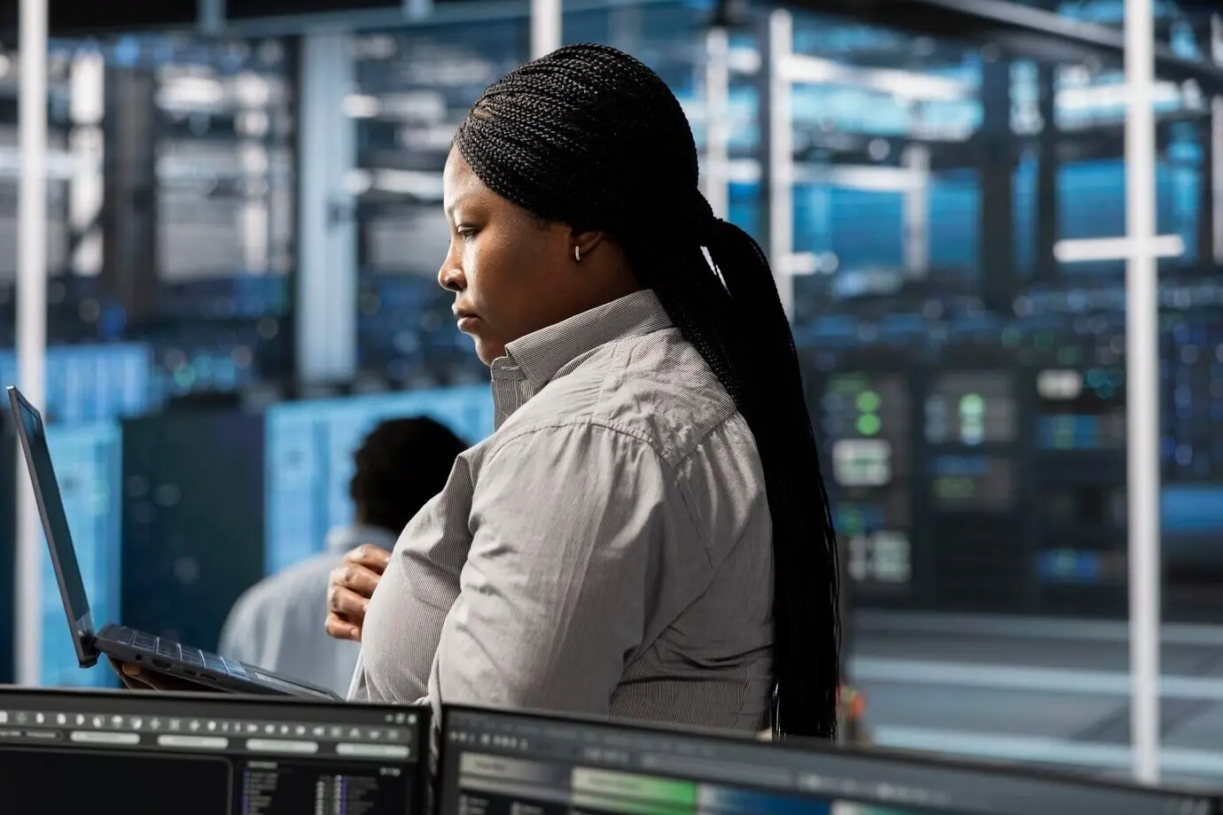 Сотрудник использует ноутбук, чтобы контролировать машины дата-центра.